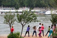 several children are practicing yoga by the water