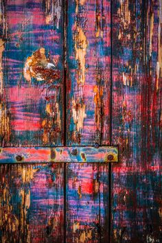 an old wooden door with peeling paint on it