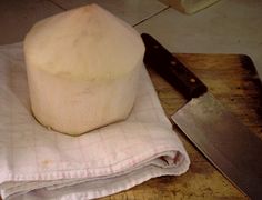 a block of cheese sitting on top of a cutting board next to a knife