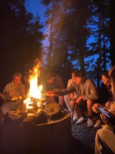 people sitting around a campfire at night