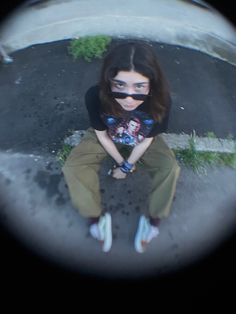 a woman sitting on the ground wearing sunglasses