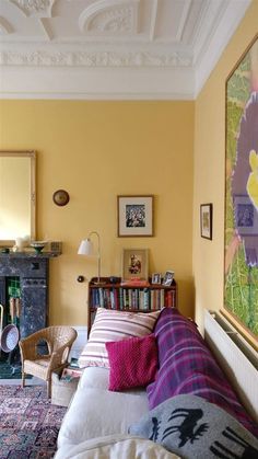 a living room filled with furniture and a painting hanging on the wall above a fire place