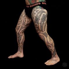 a man with tattoos on his legs and arms