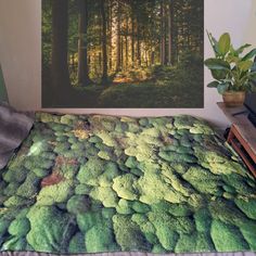 a bed with a green comforter in front of a painting on the wall above it