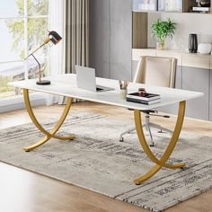 a white desk with gold legs and a laptop on it in front of a window