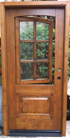 a man standing in front of a wooden door with glass panes on the side