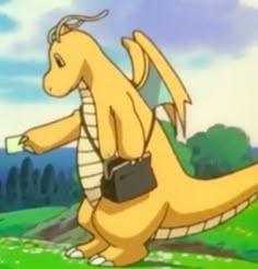 a yellow dragon sitting on top of a lush green field