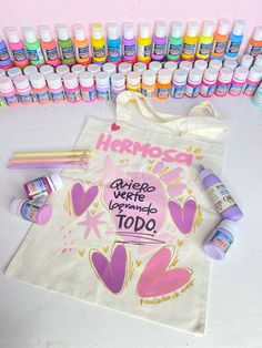 there are many different items on the table tote bags and markers, pens and glues