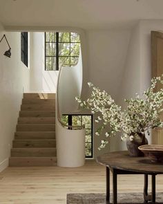 a vase with white flowers sitting on top of a table next to a stair case