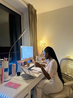 a woman sitting at a desk in front of a computer