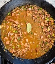 a pan filled with meat and vegetables cooking on the stove