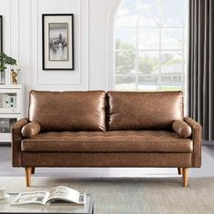 a living room with a couch, coffee table and two pictures on the wall behind it