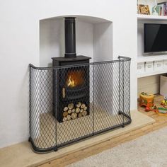 a living room with a fire place in the center and a tv on the wall