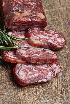 sliced sausages on a cutting board with rosemary