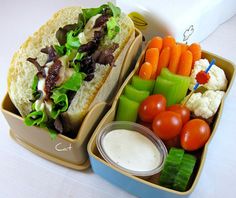 a lunch box filled with vegetables and a sandwich