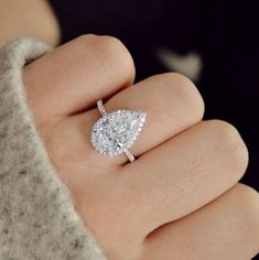 a woman's hand with a diamond ring on it