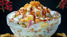 a bowl filled with food sitting on top of a wooden table next to some chips