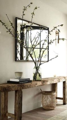 a wooden table sitting under a mirror in a living room