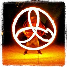 a person holding a circular object in front of their face on the street at night