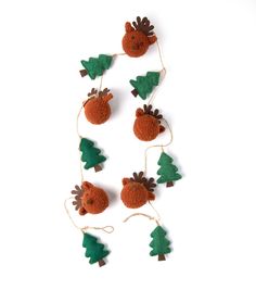 christmas decorations made out of felt with pine trees and deer heads hanging from strings on white background