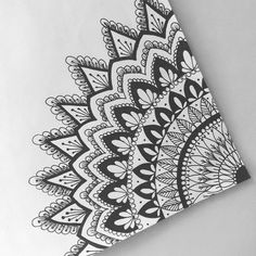 a black and white drawing of an intricate design on a piece of paper with scissors next to it