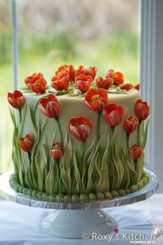 there is a cake decorated with red flowers on the top and green icing in the middle