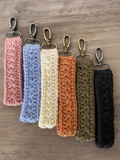 five crocheted key fobs are lined up on a table