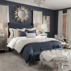 a bedroom with blue walls, white bedding and chandelier on the ceiling