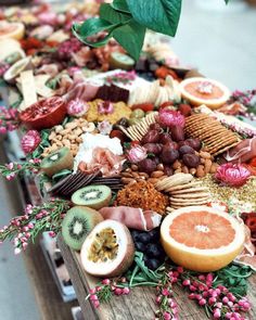 a wooden table topped with lots of different types of fruits and vegtables