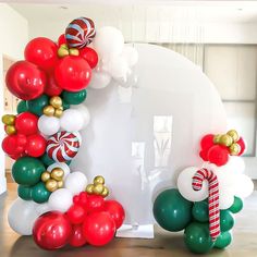 the balloon arch is decorated with candy canes and christmas decorations, along with balloons