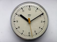 an analog clock with yellow hands and numbers on the face is shown against a white background