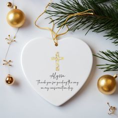 an ornament shaped like a heart with a cross on it and ornaments around it