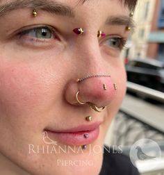 a close up of a person with piercings on their nose