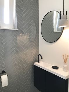 a bathroom with a sink, mirror and toilet paper dispenser in it