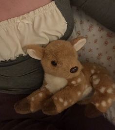 a stuffed deer laying on top of a person's stomach