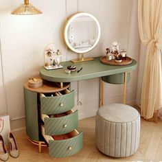 a green vanity table with drawers and a stool in front of it next to a window