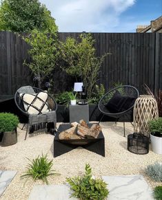 an outdoor living area with black furniture and potted plants