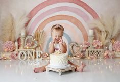 a baby sitting in front of a cake