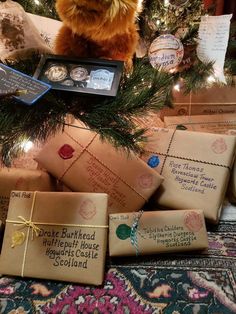 a teddy bear sitting on top of a christmas tree with presents wrapped in brown paper