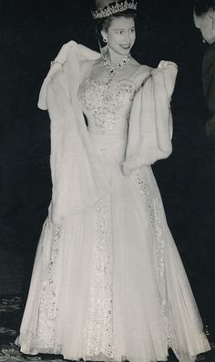 an old black and white photo of a woman in a gown with a tiara