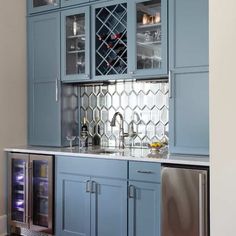 a kitchen with blue cabinetry and stainless steel appliances in the center, including a wine cooler