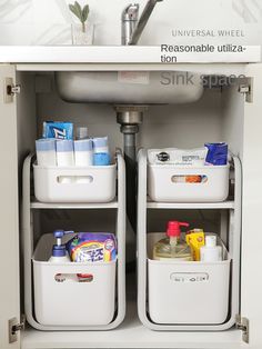 two white bins under a bathroom sink filled with cleaning supplies