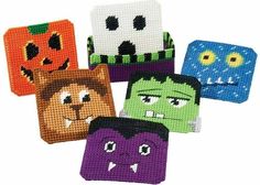 four halloween themed coasters with faces and eyes on them, all decorated in different colors