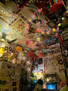 a room filled with lots of lights and pictures hanging from the ceiling over it's head