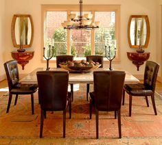 a dining room table with brown chairs and a bowl of fruit on the centerpiece