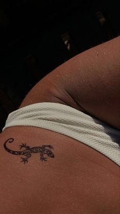 a lizard tattoo on the back of a woman's stomach