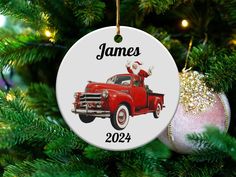 a christmas ornament hanging on a tree with a red truck and santa hat