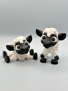 two black and white sheep figurines sitting next to each other