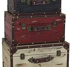 three suitcases stacked on top of each other in different colors and sizes, all with leather straps