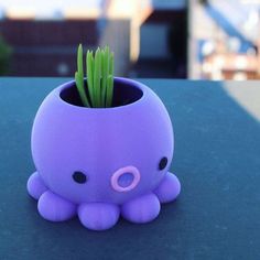 an octopus planter is sitting on a table with grass in it's mouth